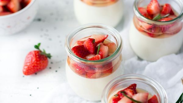 Small cups of yogurt topped with strawberries