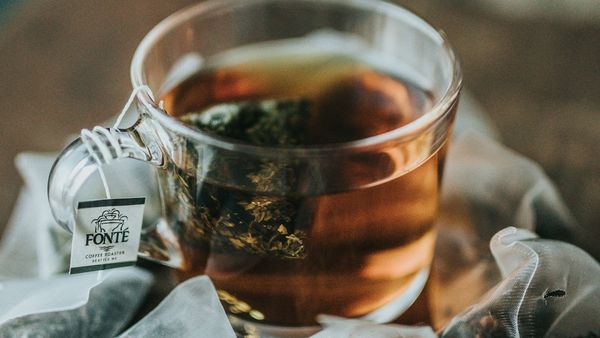 A glass cup of tea with a tea bag